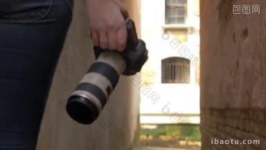 斯坦尼康拍摄的女摄影师走在狭窄的小巷与专业的摄影相机在她的手寻找一个地方